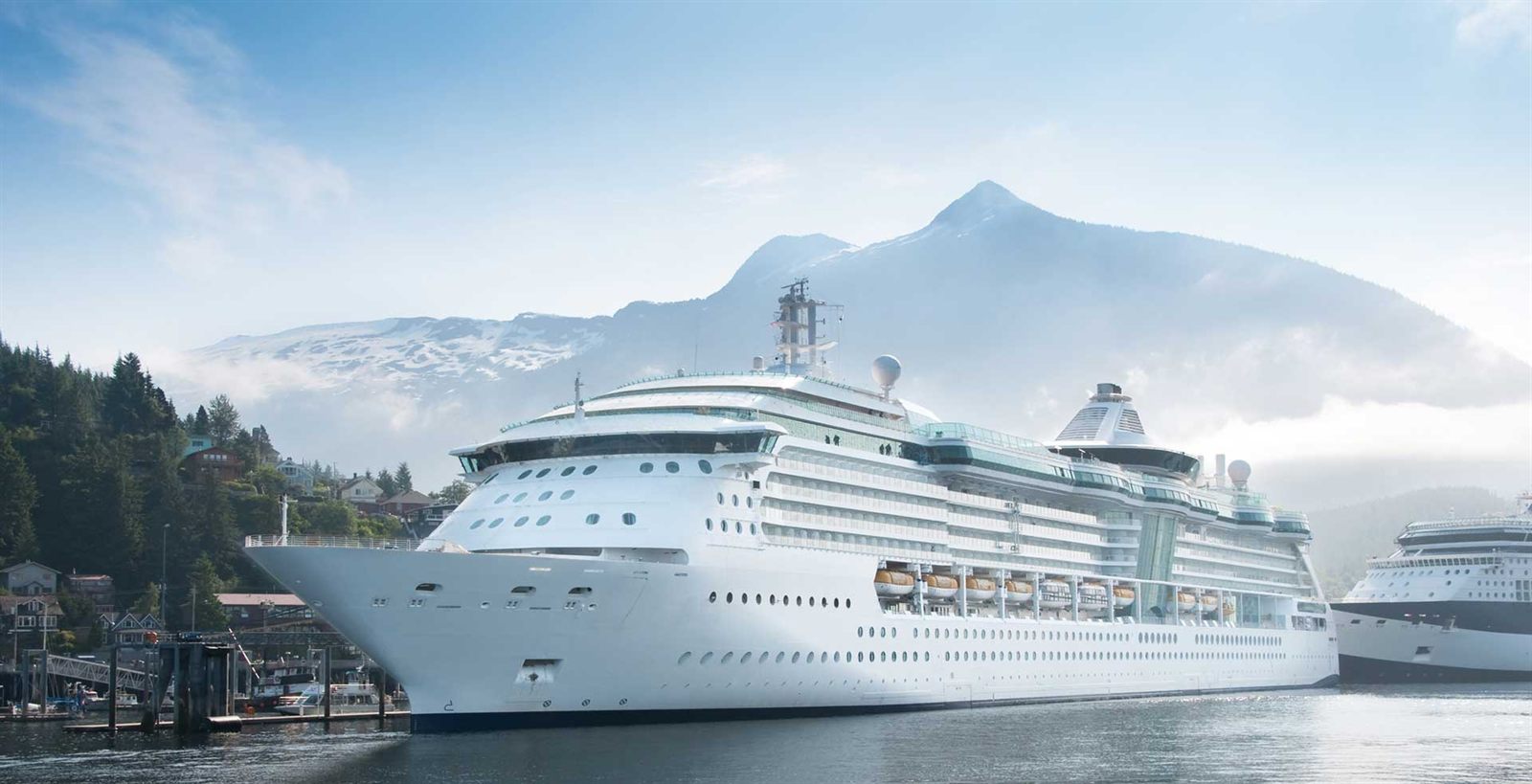 Cruise ship docked beneath snow-capped mountains